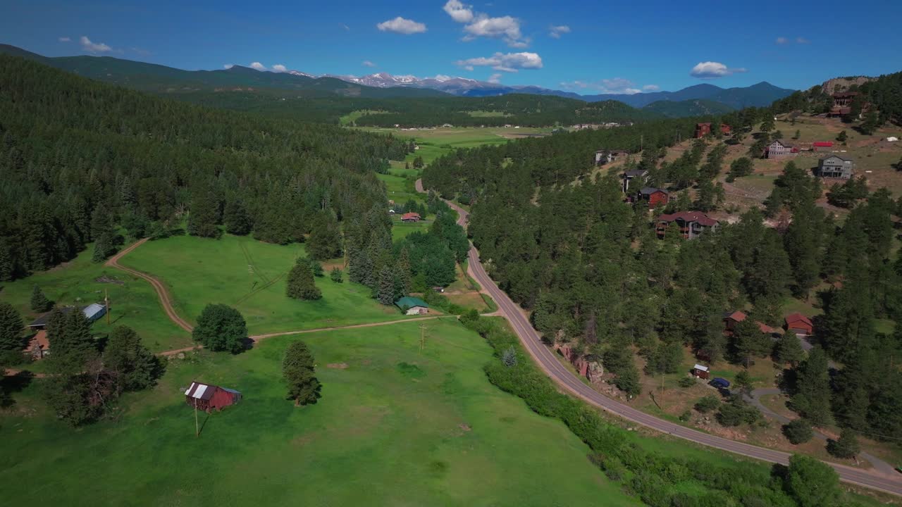 Mount Blue Sky Evans aerial drone neighborhood south Evergreen Colorado Rocky Mountains landscape Spring Summer morning North Turkey Creek Road Traffic Red Barn Marshdale sunny forward pan up reveal