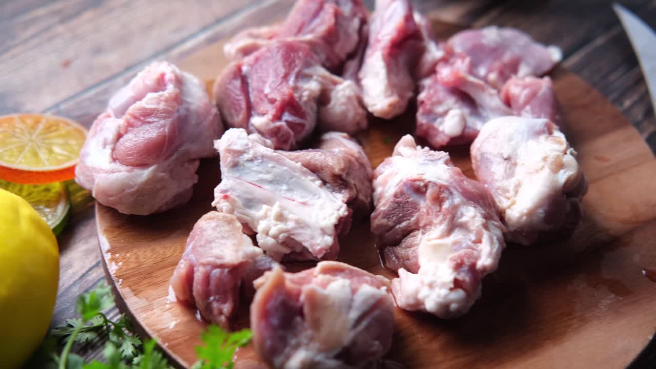 trozos de carne cruda en una tabla de cortar de madera