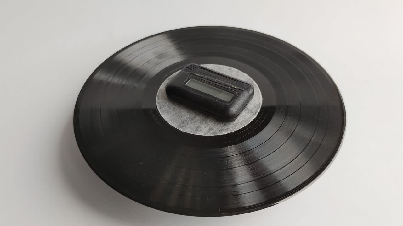 페이저와 비닐 디스크. 오래된 빈티지 비퍼. 페이저는 회전하는 비닐 레코드에 있습니다.