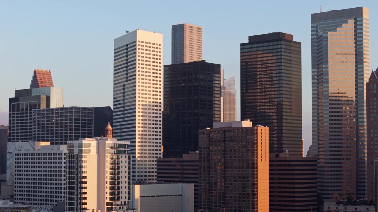 O impressionante horizonte de Houston se destaca contra um pano de fundo de tons quentes de pôr do sol, exibindo a energia vibrante da maior cidade do Texas, filmagem de drone em órbita