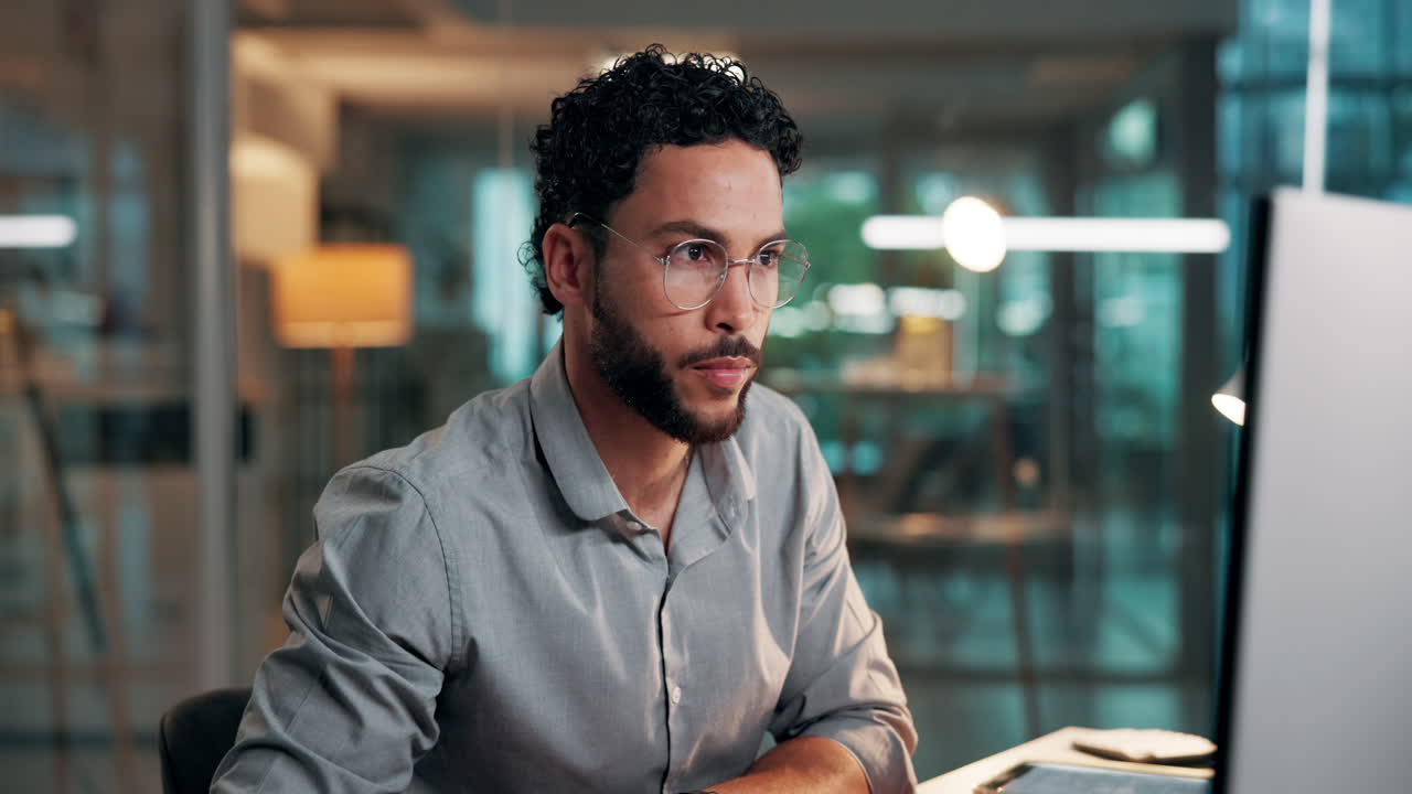 Young Man Working on Computer in Modern Office at Night
