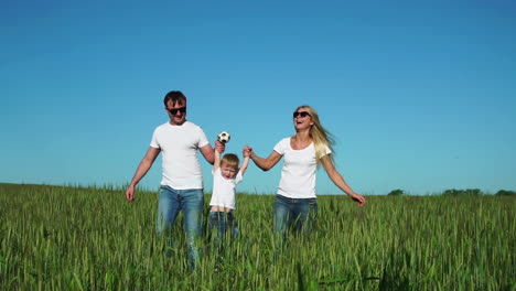 Familia-Feliz:-Padre,-Madre-E-Hijo,-Corriendo-Por-El-Campo-Vestidos-Con-Camisetas-Blancas