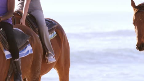 People-riding-horse-on-beach