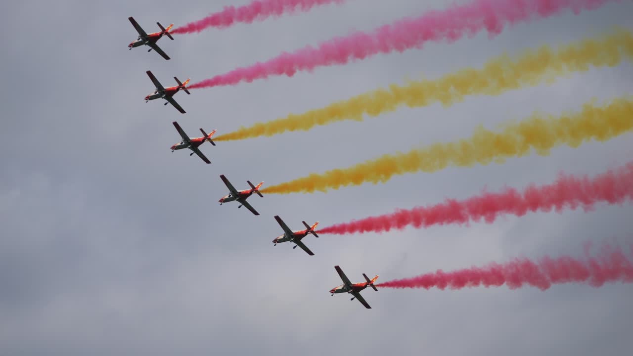 The Patrulla Águila aerobatic team of the Spanish Air Force fly through the air at Airpower and display the Spanish flag in the form of smoke