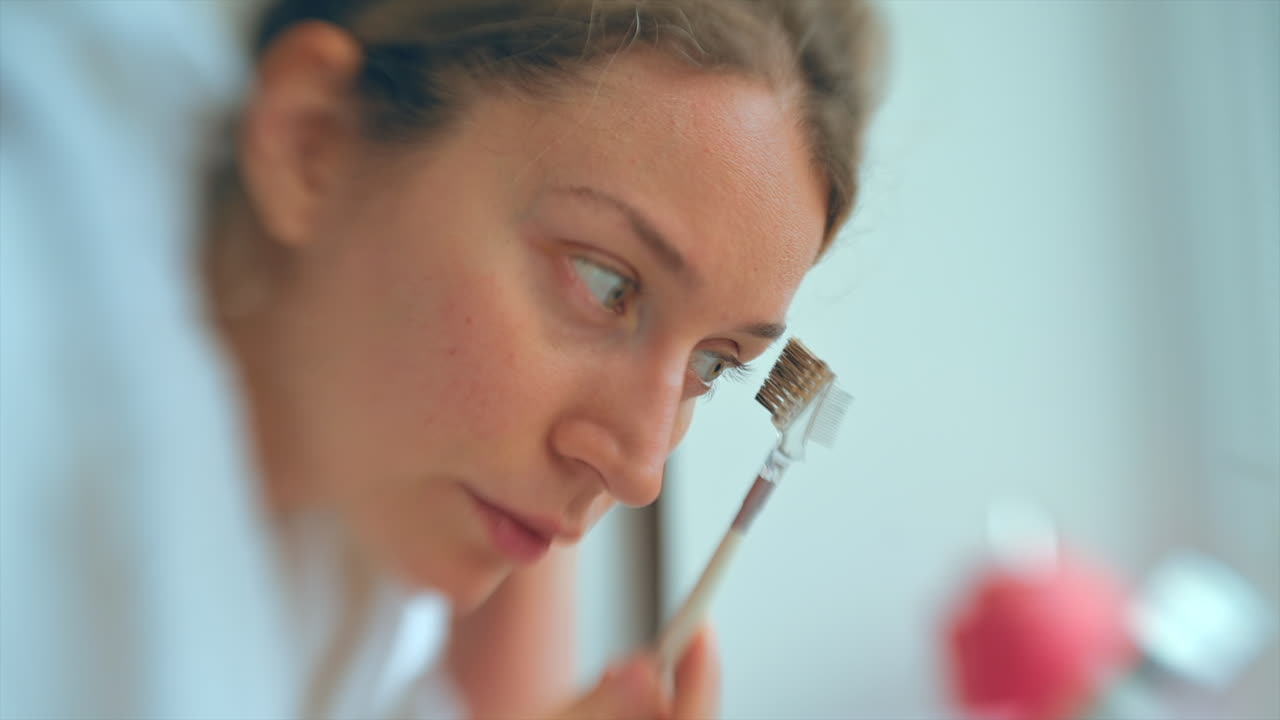 Woman shaping her eyebrows in the bathroom