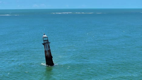 Drone view of ruined lighthouse where the São Francisco River meets the Atlantic Ocean