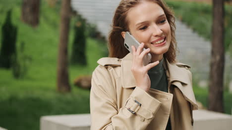 Caucasian-female-student-talking-on-the-phone-outdoors.