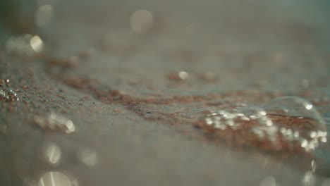 Close-up-view-of-soft-waves-of-lake-water-hitting-the-shore