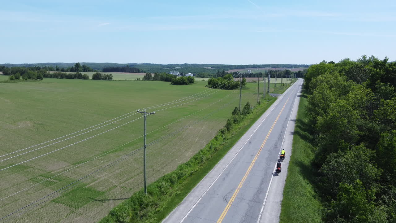 두 명의 자전거 여행객이 캐나다 의 도로를 타고 있습니다.