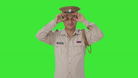 happy indian police officer wearing hat and getting ready green screen