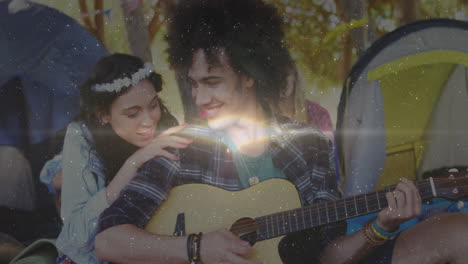 playing guitar outdoors, couple smiling and listening to music together