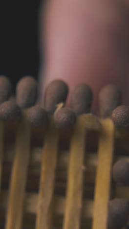 man holds nice small toy house made from wooden matches and shows different sides on light background macro