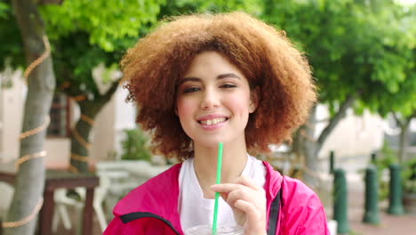 retrato de una mujer con una bebida afro roja