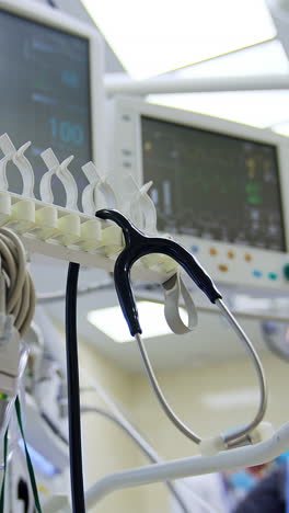 equipment, wires, devices and instruments in modern surgical room. low angle view. medics working at backdrop. vertical video