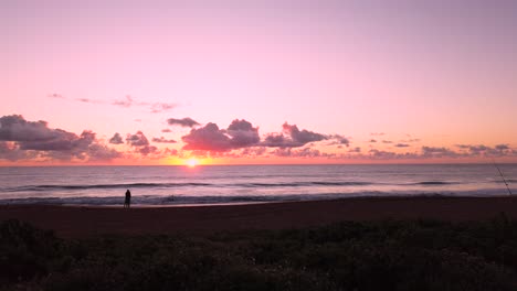 uhd hawaii kauai estática de una pareja en la distancia en la playa viendo un amanecer parcialmente nublado