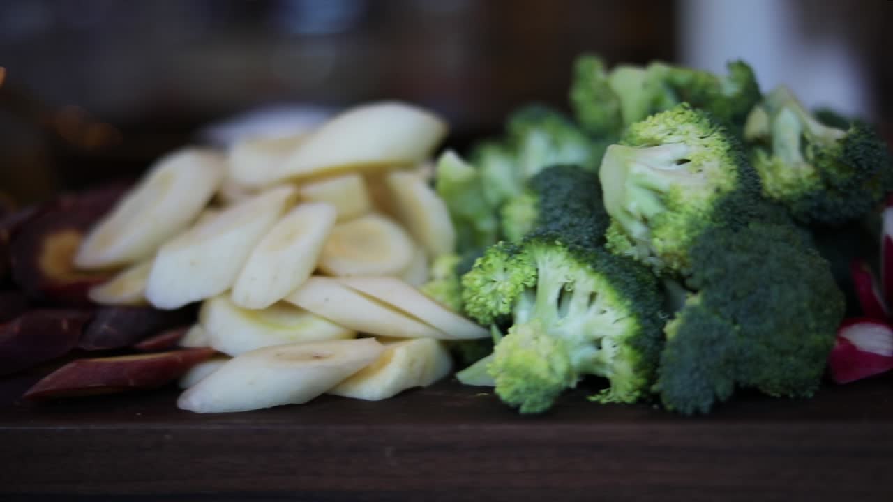 A slow Panning Shot over a platter of vegetables including broccoli, cauliflower, mushrooms, carrots, beats, radishes, peas, etc..
