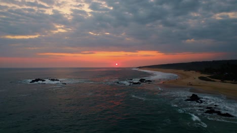 Vista-Aérea-De-Una-Cálida-Puesta-De-Sol-Sobre-Las-Playas-De-Puerto-Escondido,-México