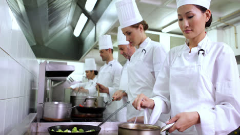 Chef-stirring-sauce-smiling-at-camera