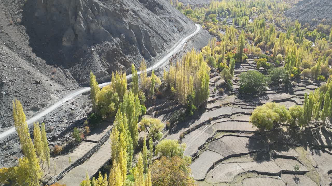 vuelo de avión no tripulado sobre el valle con árboles verdes y un río en la ciudad de skardu