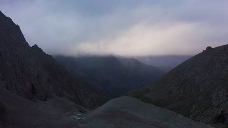 aerial cinematic drone shot of the foggy peaks of the ak-sai glacier in kyrgyzstan