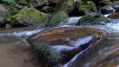 Klares-Wasser-Aus-Dem-Wasserfall,-Der-Durch-Große-Felsen-Im-Wald-Fließt