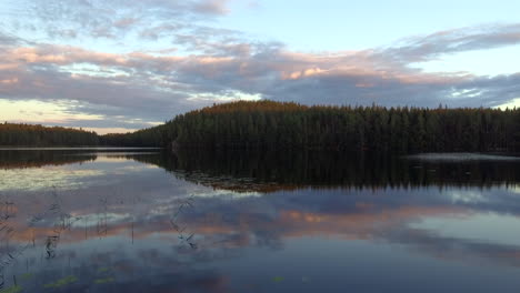 stunning drone footage of a calm lake by dusk in the borealis wilderness