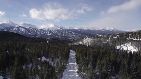 snowy road path in silverthorne forest on a sunny winter day