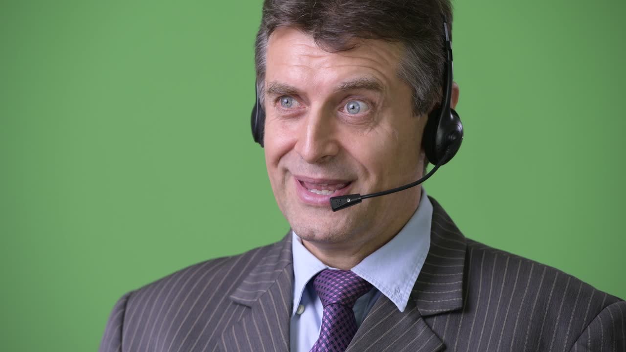 hombre de negocios maduro y guapo contra un fondo verde