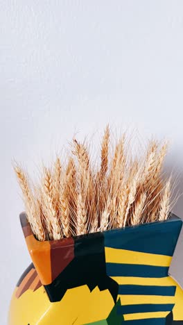 trigo seco en un jarrón de colores