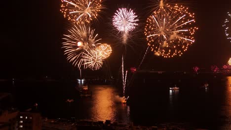 Vista-Aérea-Inclinada-De-Un-Grupo-De-Barcos-En-La-Costa-De-Valparaíso,-Exhibición-De-Fuegos-Artificiales-De-Nochevieja,-Costa-Chilena.