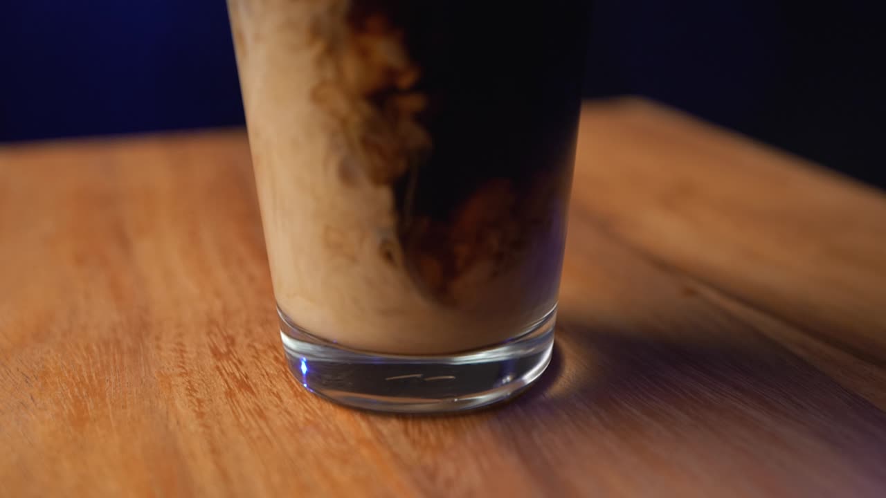 Latte che si mescola in una bevanda fredda al caffè.
