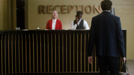 receptionists assisting guests with check-in at the hotel