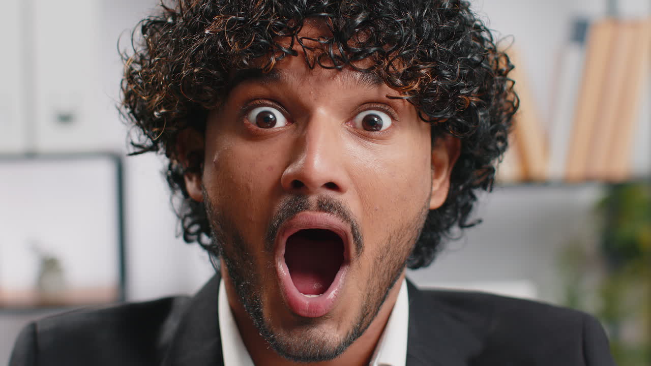 Businessman working at home office taking off glasses shocked by sudden victory lottery winning