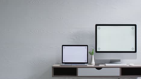 Video-of-computer-and-laptop-on-wooden-table-with-copy-space-in-office