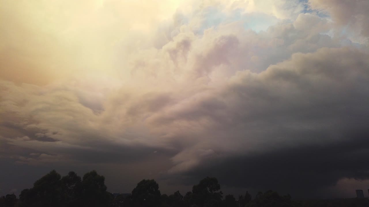 Storm cell evolving over a western Sydney city in Australia. Dynamic color changes during sunset captured as timelapse