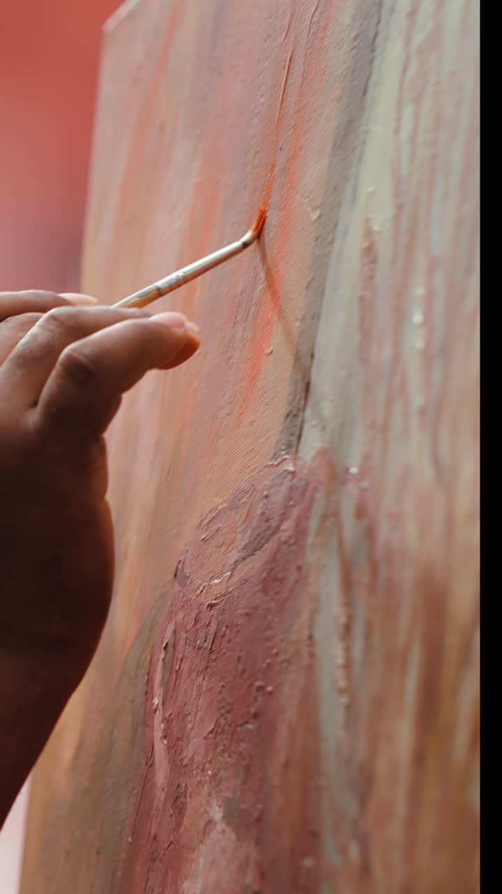 Close-Up of Artist's Hand Painting on Canvas with a Brush