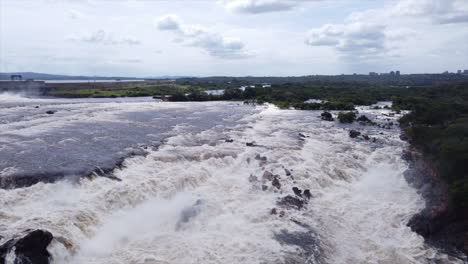 una toma aérea que se mueve hacia adelante siguiendo las cascadas de la llovizna mientras caen en cascada por el acantilado rocoso