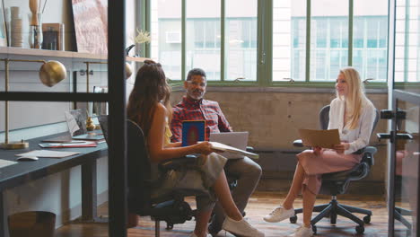 three creative business people in an informal office meeting