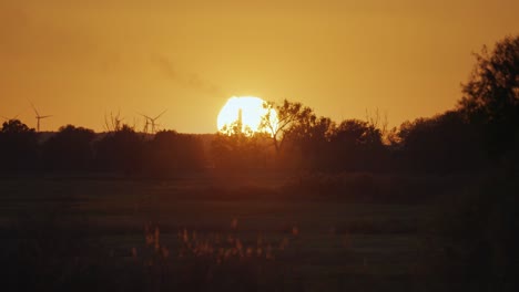 El-Disco-Ardiente-Naranja-Brillante-Del-Sol-Poniente-Desciende-Lentamente-Sobre-El-Horizonte