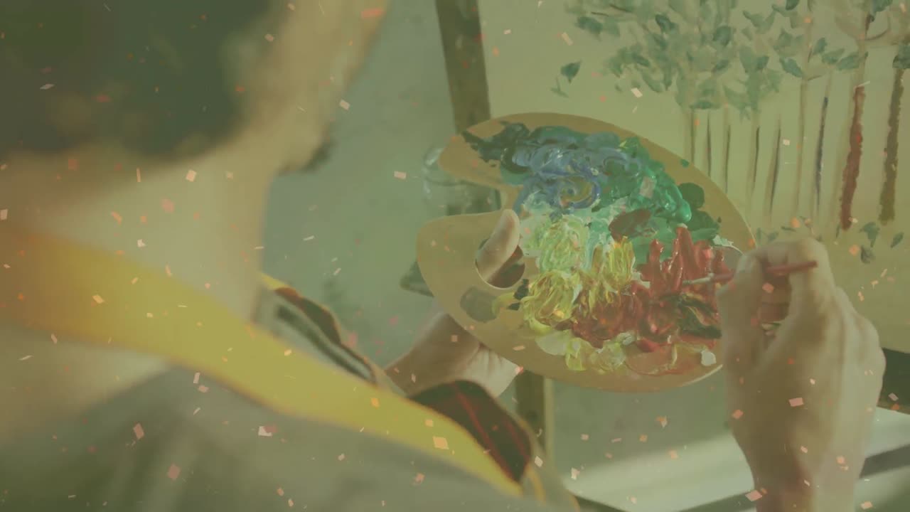 스튜디오에서 그림 그리는 백인 남자의 클로즈업에 맞서 떨어지는  ⁇ 은 입자