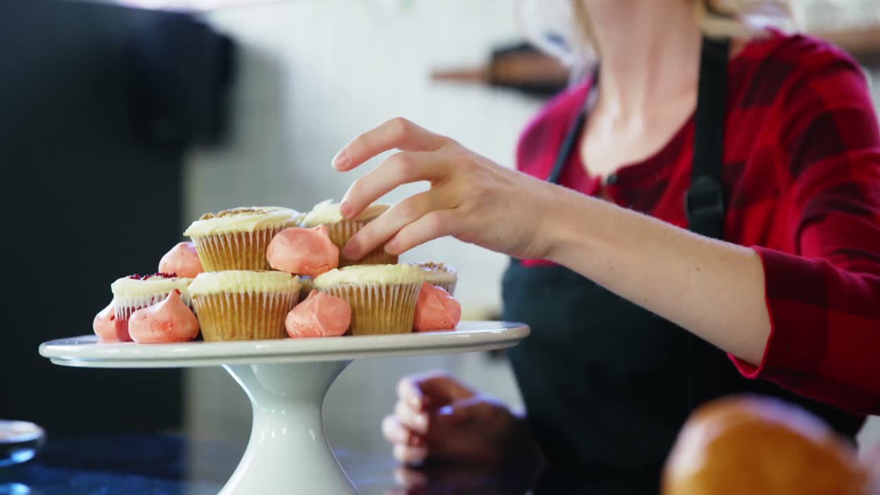 케이크 스탠드 에 컵케이크 를 정리 하는 웨이트리스