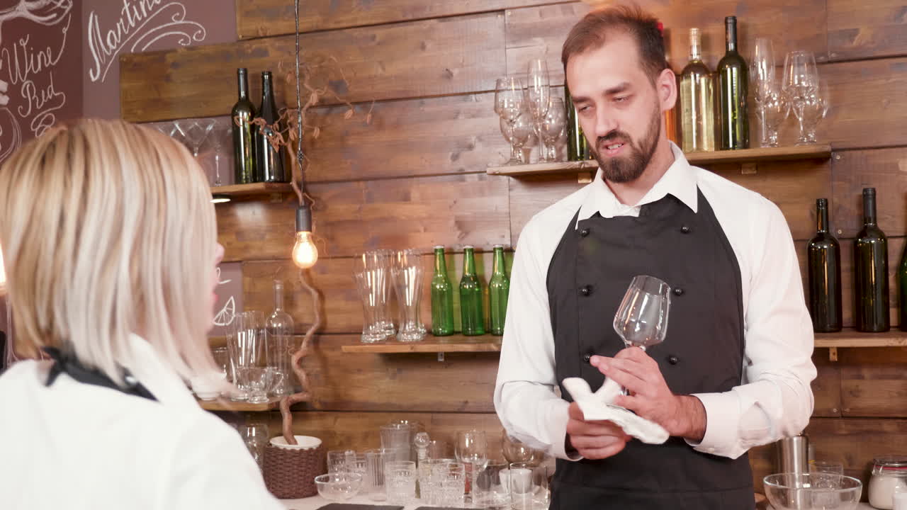 Bartender Cleaning Wine Glass at Bar