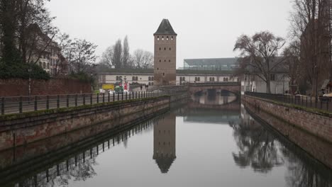 View-at-the-peaceful-and-tranquil-river-the-Ponts-Couverts,-a-set-of-bridges-and-towers-that-make-up-a-defensive-work-erected-in-the-13th-century-on-the-River-Ill-in-the-city-of-Strasbourg-in-France