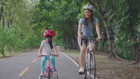 mother and daughter cycling in park