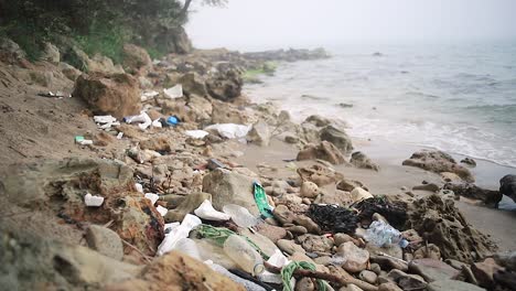desastre plástico, lleno de desechos plásticos en una playa de arena brumosa