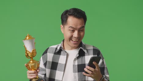 happy man celebrating a win with a trophy