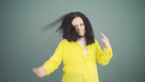 young woman doing rocker sign and dancing.