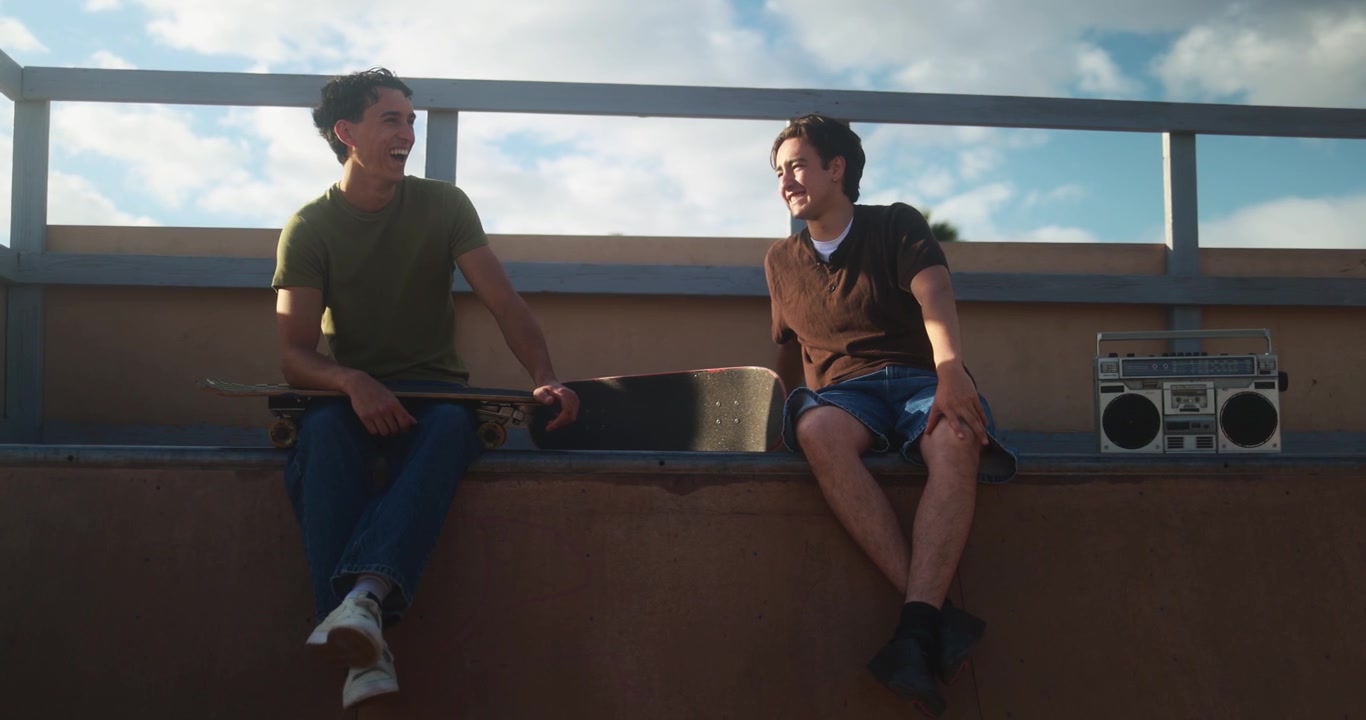 Two Young Men Laughing and Talking at a Skatepark