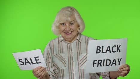 abuela mayor mostrando la palabra de venta y las pancartas publicitarias de inscripción de viernes negro. descuentos