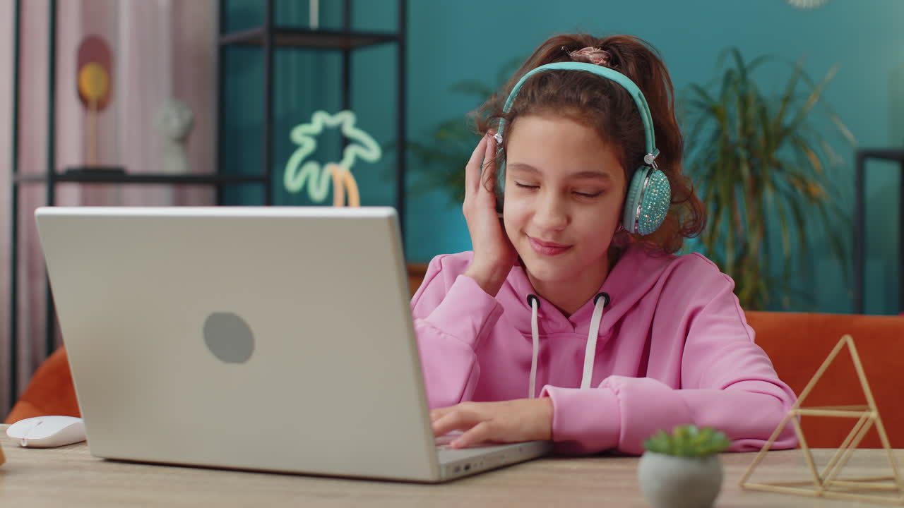 Preteen school girl in headphones listens to music or lesson distance online learning relaxing
